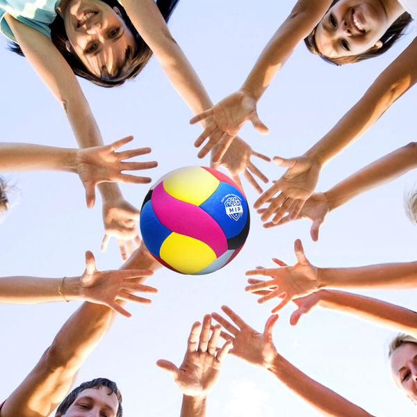 Colorful beach volleyball surrounded by hands of diverse players against a bright sky.